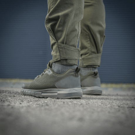Mand iført M-Tac Bukser Patriot Gen.III Vintage, taktiske bukser til træning og fritid, vises med sneakers på asfalt.