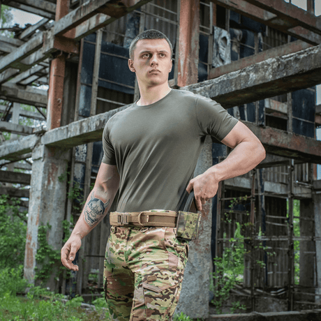 Mand iført M-Tac T-shirt 93/7 Summer i en industriel omgivelse