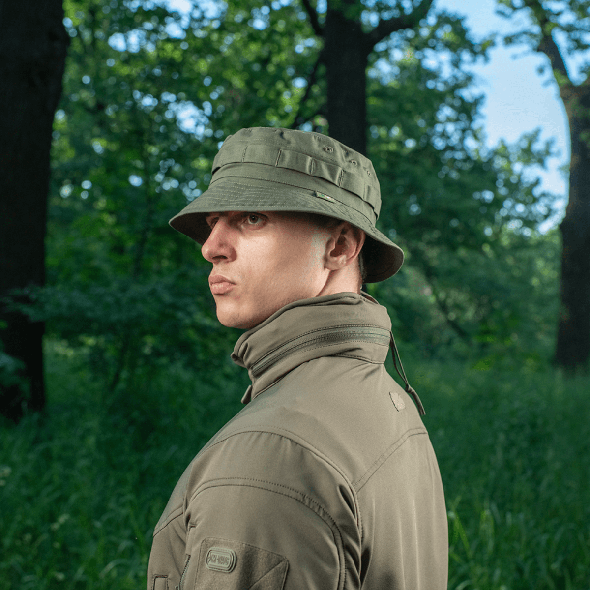 Mand iført M-Tac Panama Rip-Stop army-hat i skovmiljø, viser semi-stiv skygge og ventilationshuller.