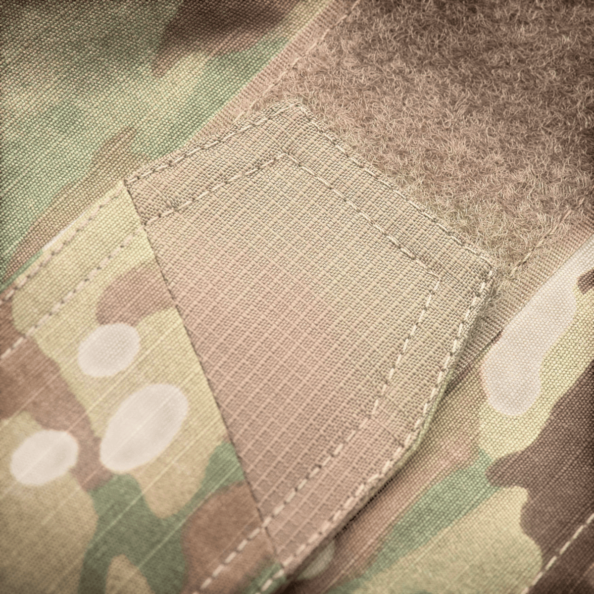 Nærbillede af M-Tac Bukser Aggressor Elite NYCO design, viser amerikansk NYCO rip-stop stof i kampremønster. Optimal slidstyrke.