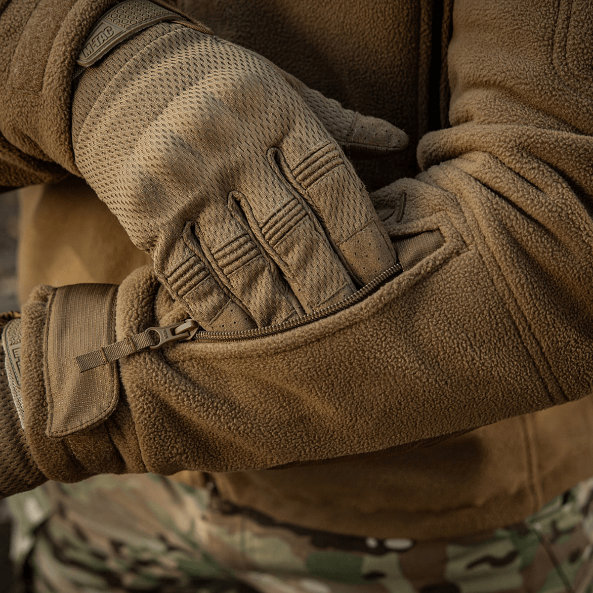 Person iført M-Tac Division Gen.II Windblock Fleecejakke med lynlåsdetaljer, designet til vindbeskyttelse i koldt vejr.