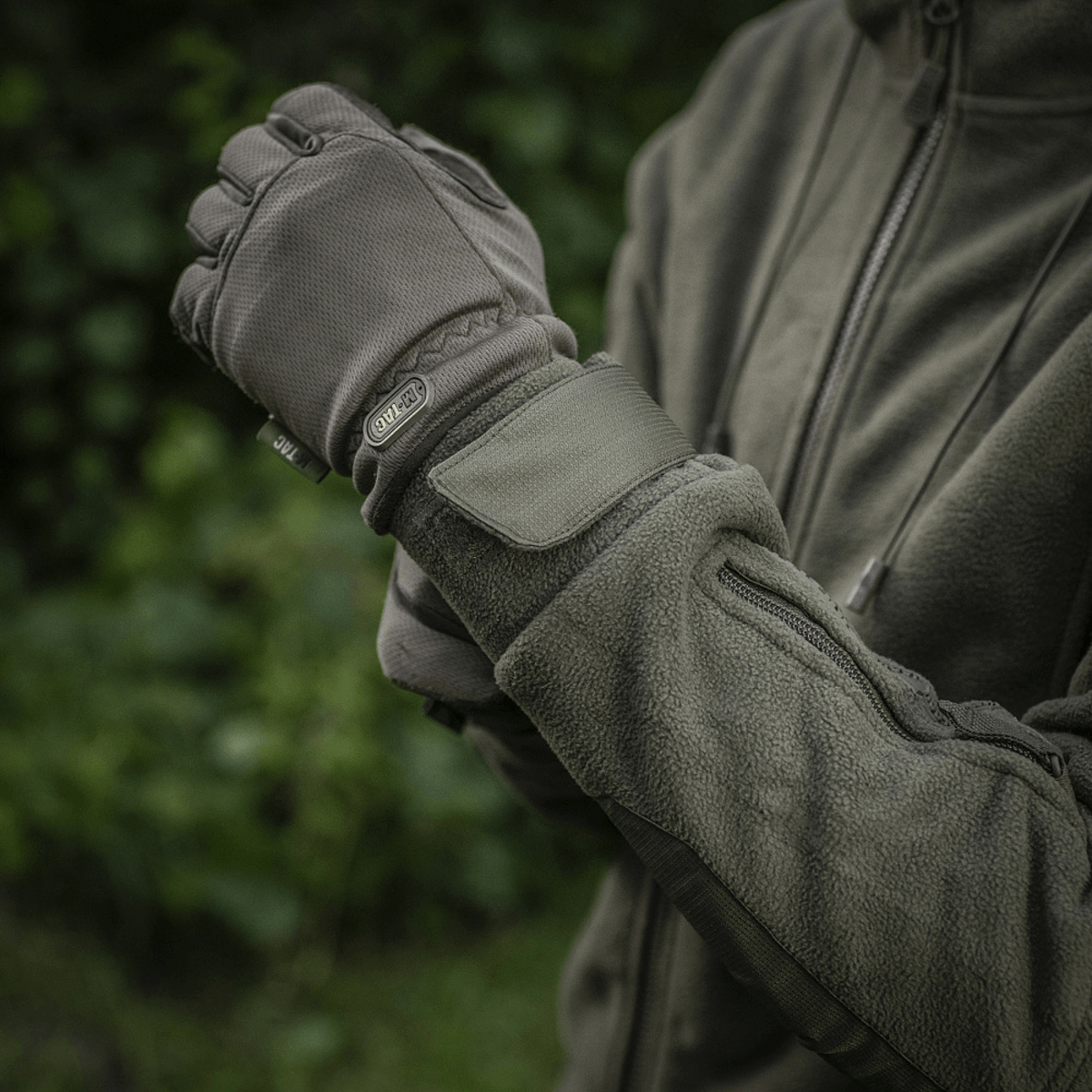 Mand iført M-Tac Division Gen.II Windblock Fleecejakke i en have