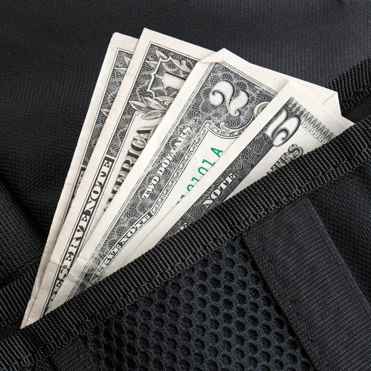 Dollarsedler i en sort pung af 1000D CORDURA®, M-Tac Pung med Patch Panel Elite, designet til taktiske bukser med kreditkort rum.