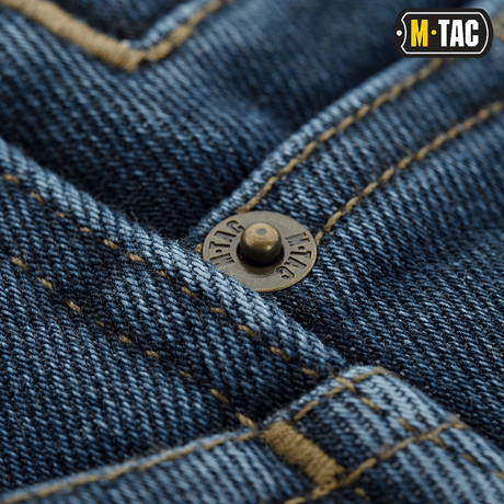 Nærbillede af M-Tac Jeans Tactical Gen. I Cordura Regular Fit med forstærket denim og metal-knapdetaljer.