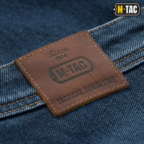 Nærbillede af M-Tac Jeans Tactical Gen. I Cordura Regular Fit med læderemblem på baglommen.