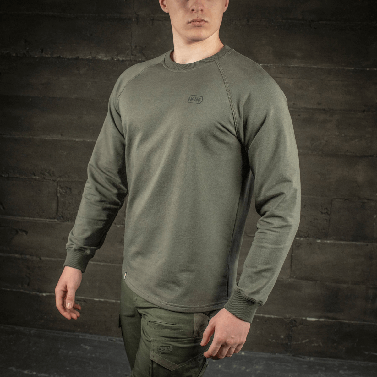 M-Tac Raglan Athlete i olivenfarve med raglanærmer og rund hals, perfekt til sport og hverdagsbrug, båret af model