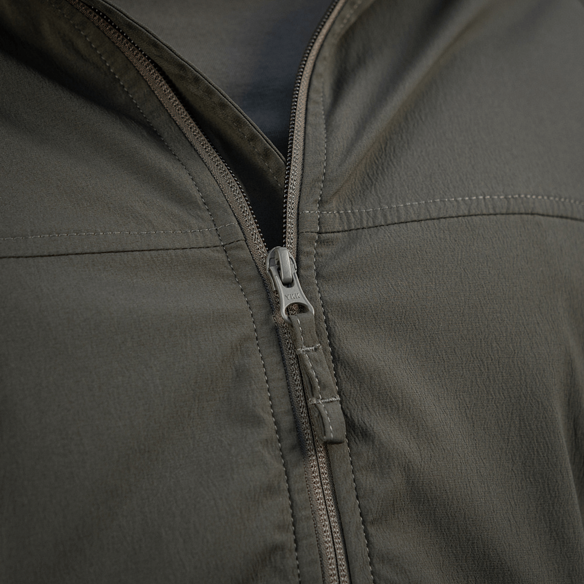 M-Tac Flash Jakke lynlåsdetalje i nærbillede, letvægts og alsidig, perfekt til vandreture og daglig brug, uden velcro på ærmerne.