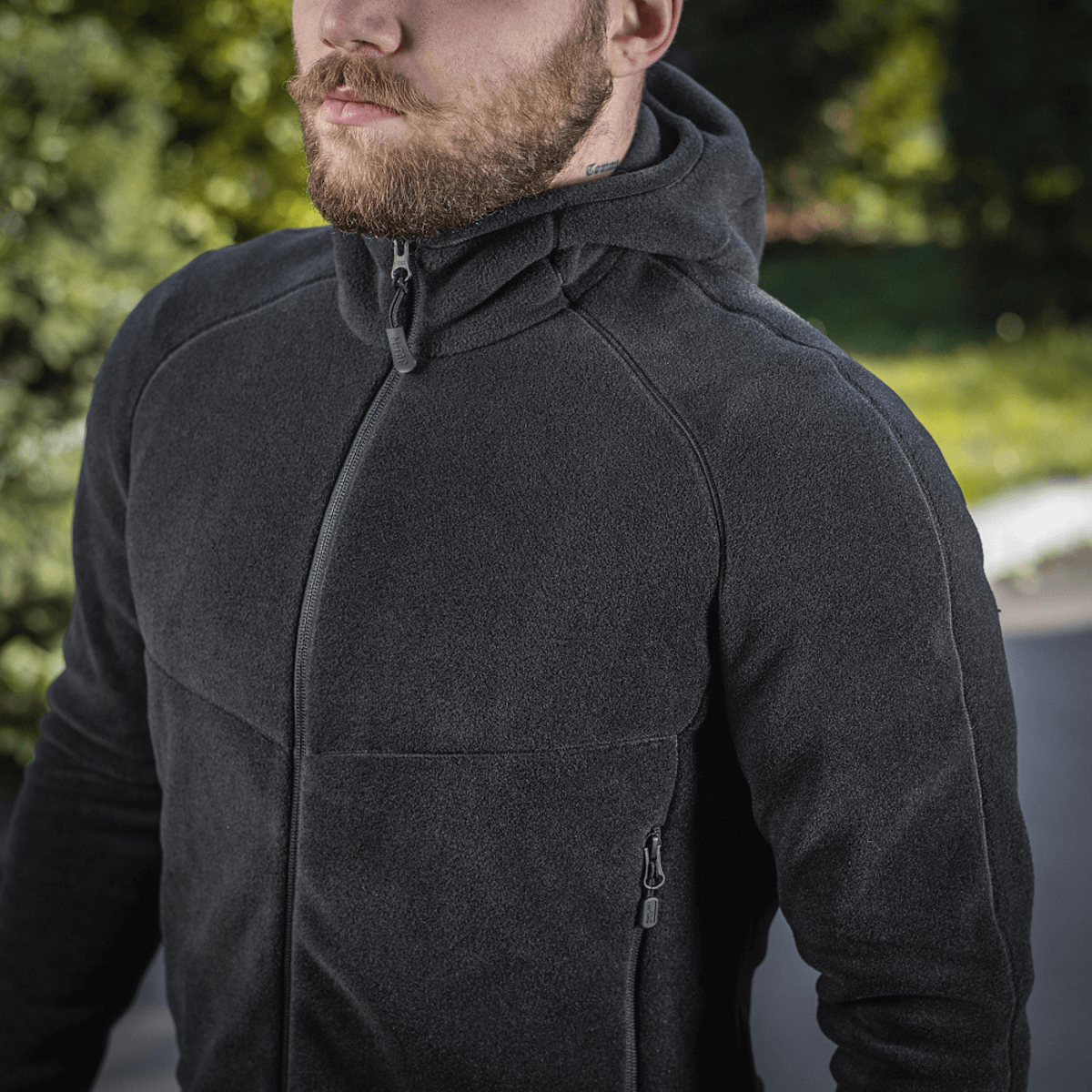 Mand iført M-Tac Sprint Fleece Sweatshirt Polartec i sort, stilfuld og funktionel hættetrøje perfekt til daglig brug og aktiviteter.