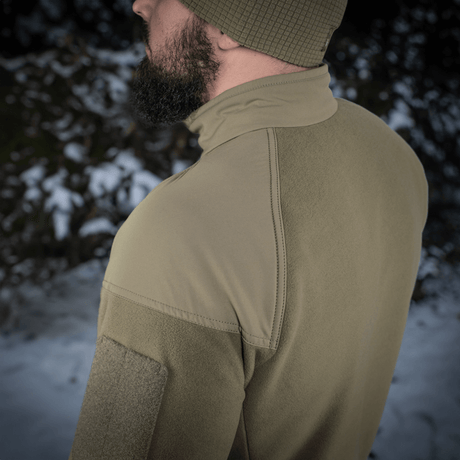 Mand iført M-Tac Combat Fleece Polartec Jakke i naturen, med YKK lynlåse og Polartec® fleece for varme og holdbarhed