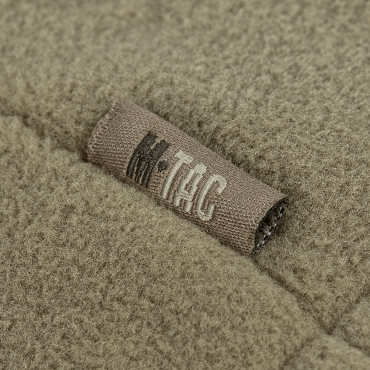 Nærbillede af M-Tac Combat Fleece Polartec Jakke med mærke på fleece materialet, fremhæver kvalitet og design.