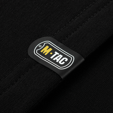 Close-up af M-Tac logo på M-Tac Raglan Odin Mystery trøje i sort stof, viser kvalitetsdesign og materiale