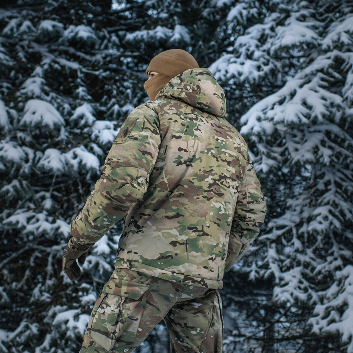 Person iført M-Tac Alpha Gen.IV Pro Primaloft Vinterjakke i sneklædt skov, ideel til koldt klima.