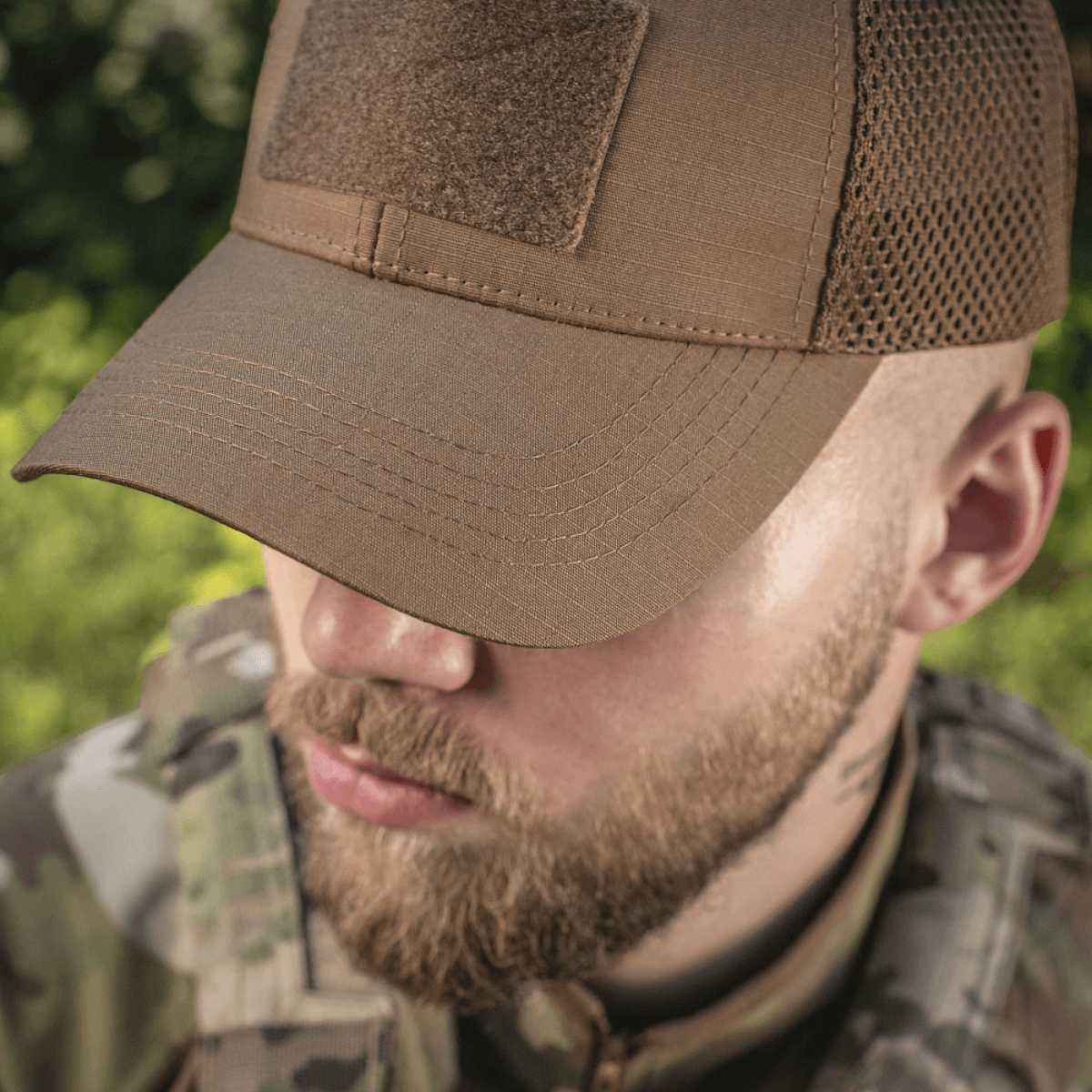 M-Tac Baseball Cap Ripstop Elite Flex i beige på en taktisk baggrund, ideel til udendørsbrug og stilfulde eventyr.
