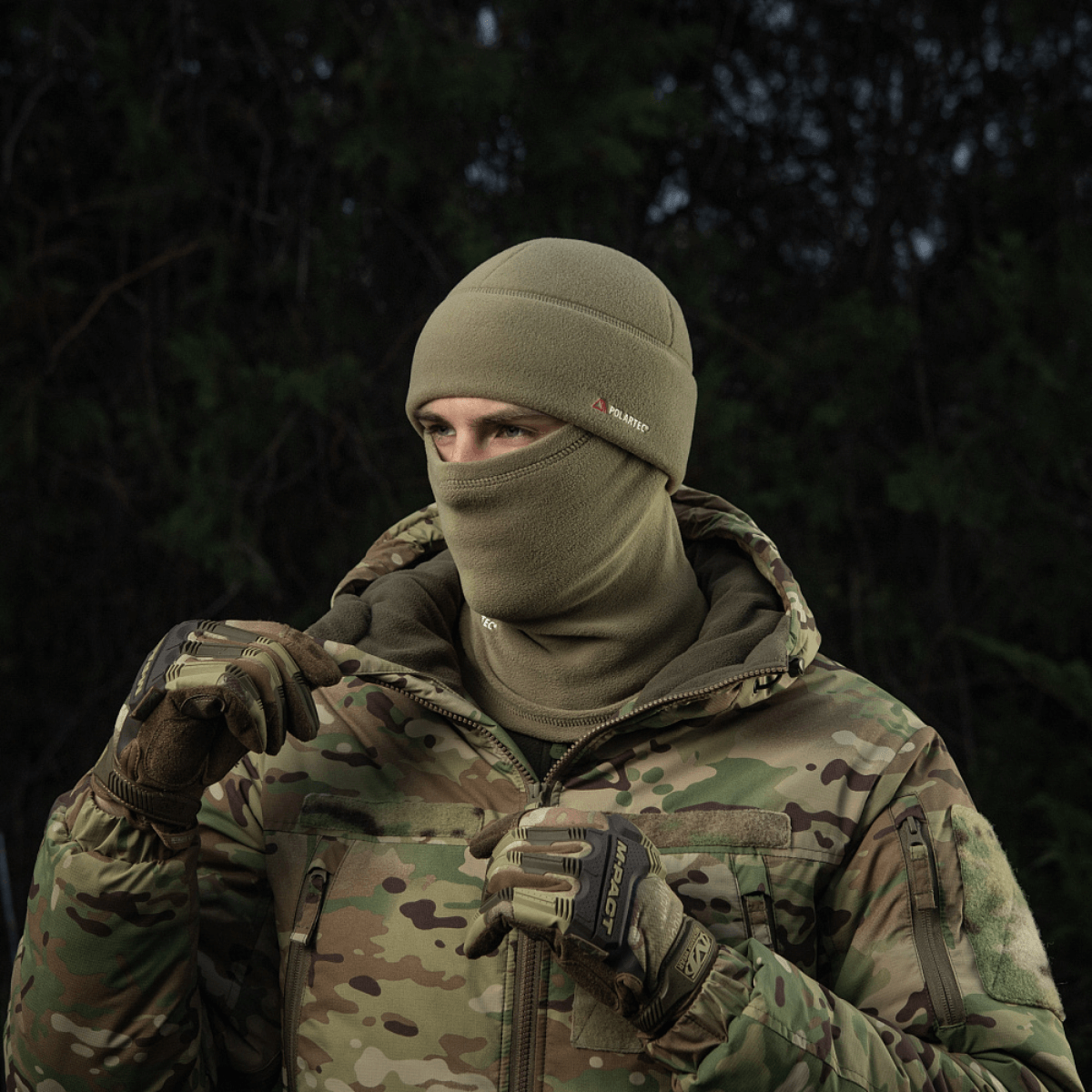 Person iført M-Tac Fleece Polartec Watch Cap i koldt udendørs miljø, perfekt til vinteraktiviteter med kamuflagejakke.