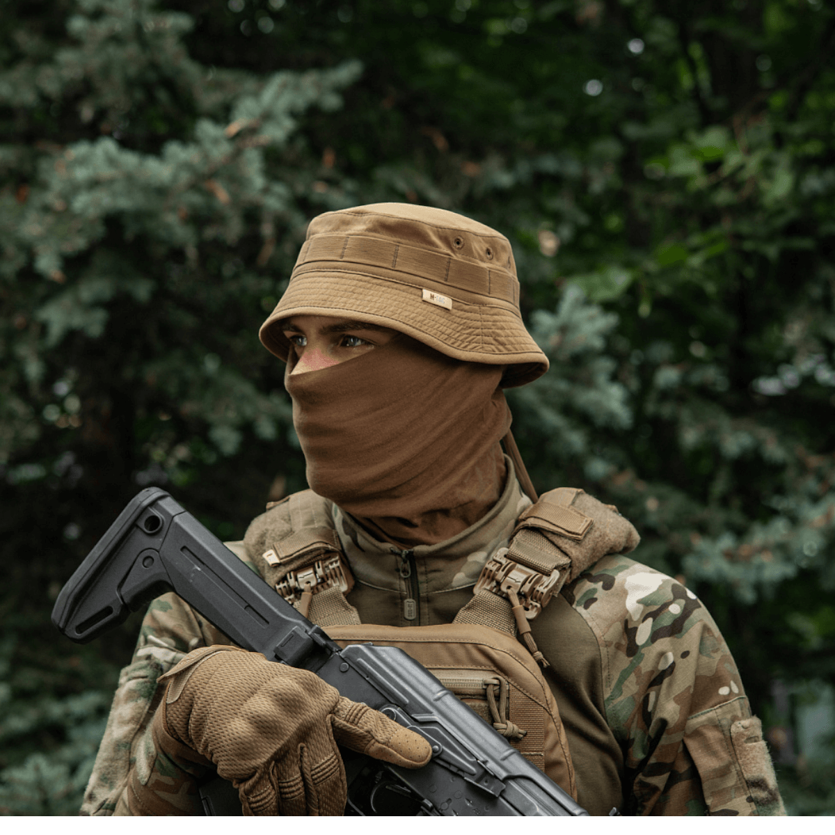 Person iført M-Tac Panamahat Gen. II Summer Flex i skov, camouflage outfit, bevæbnet, sommerbeklædning