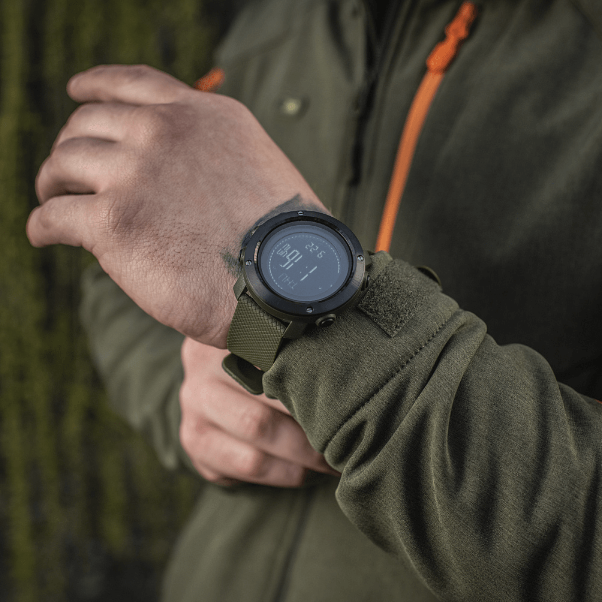 M‑Tac Multifunktionelt Taktisk Ur med elektronisk kompas og 3D pedometer set på en hånd, ideel til friluftsliv og militærbrug.