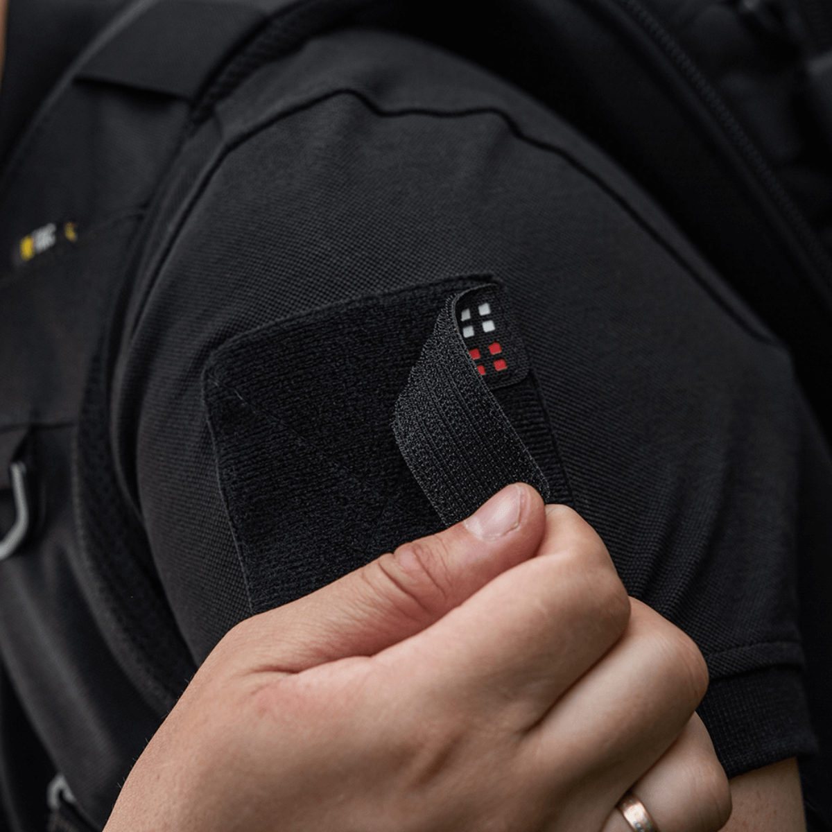 M-Tac Patch Flag 25x80 Mini Squares fastgjort til tøj med velcro, fremstillet af slidstærk Cordura 500D, viser taktisk anvendelse.