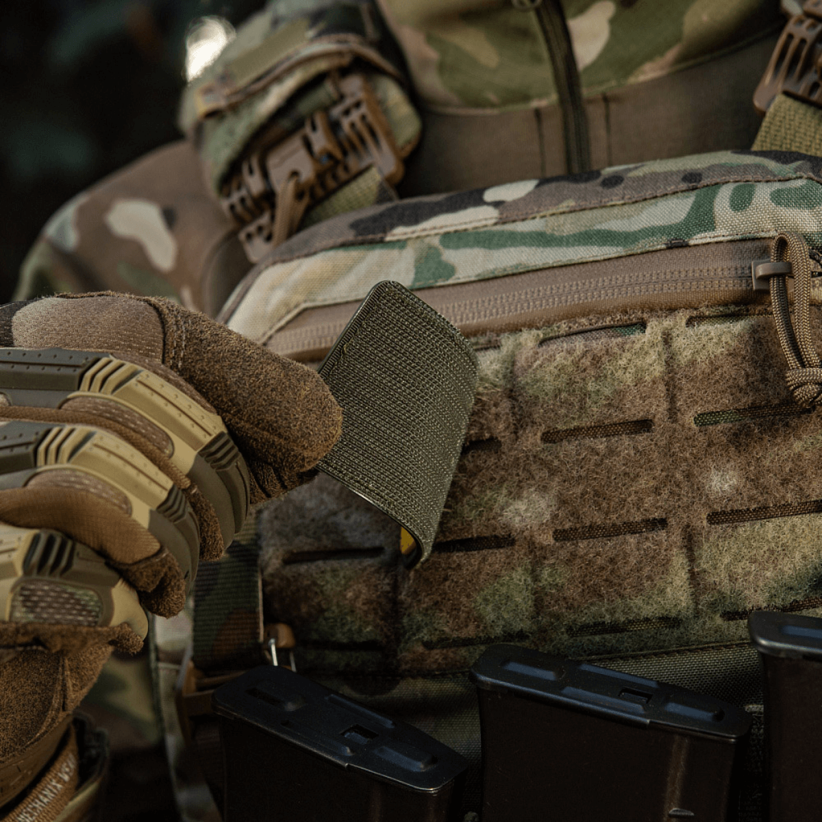 Soldat i camouflage holder M-Tac Patch Ukraine Flag med Våbenskjold med Velcro på udstyr.