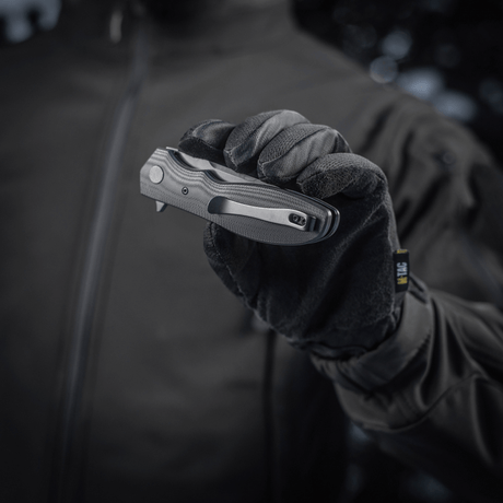Person holding M-Tac Outdoor & Militær foldekniv - Type 6 with black G10 composite handle in gloved hand