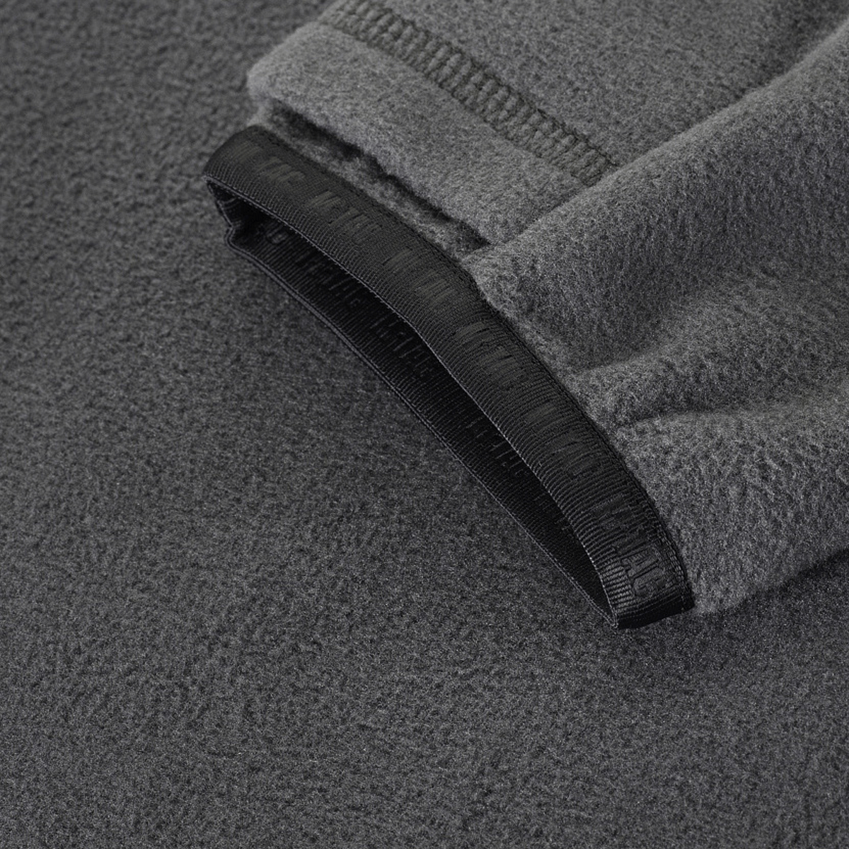 M-Tac Delta Polartec Fleecejakke i grå Polartec® Micro Series-fleece, der viser jakkens tekstur og manchet.