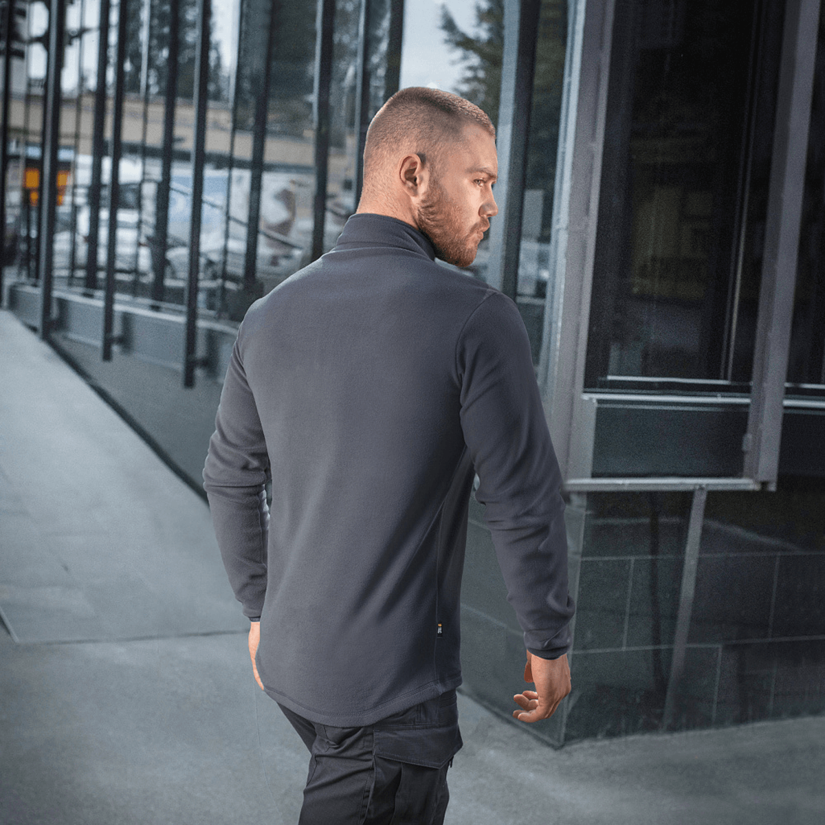 M-Tac Delta Polartec Fleecejakke til mænd, set bagfra i moderne urbant miljø, fremstillet af Polartec Micro Series-fleece