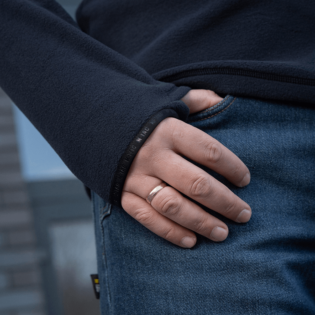 Nærbillede af en person iført en M-Tac Delta Polartec Fleecejakke med hånden i lommen, fremviser jakkeens slidstærke design