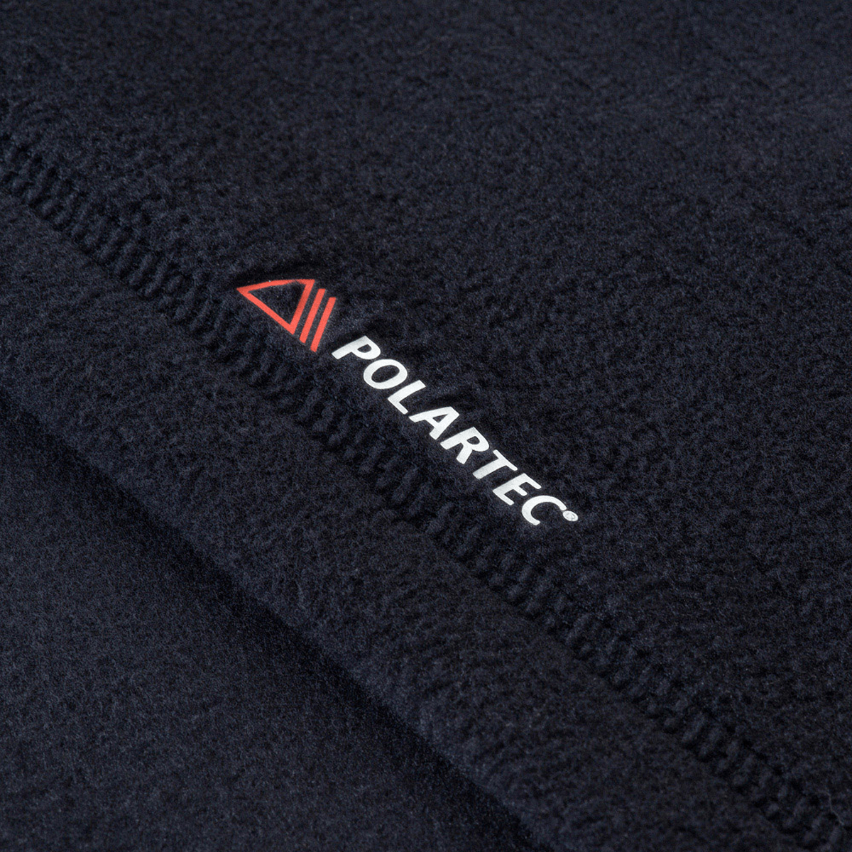 Nærbillede af M-Tac Delta Polartec Fleecejakke med Polartec® logo, lavet af slidstærkt og varmt Polartec® Micro Series-fleece.