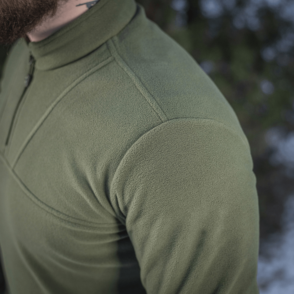 M-Tac Delta Polartec Fleecejakke i grønt, fremstillet af Polartec® Micro Series-fleece, viser blød og åndbar tekstur i natur.