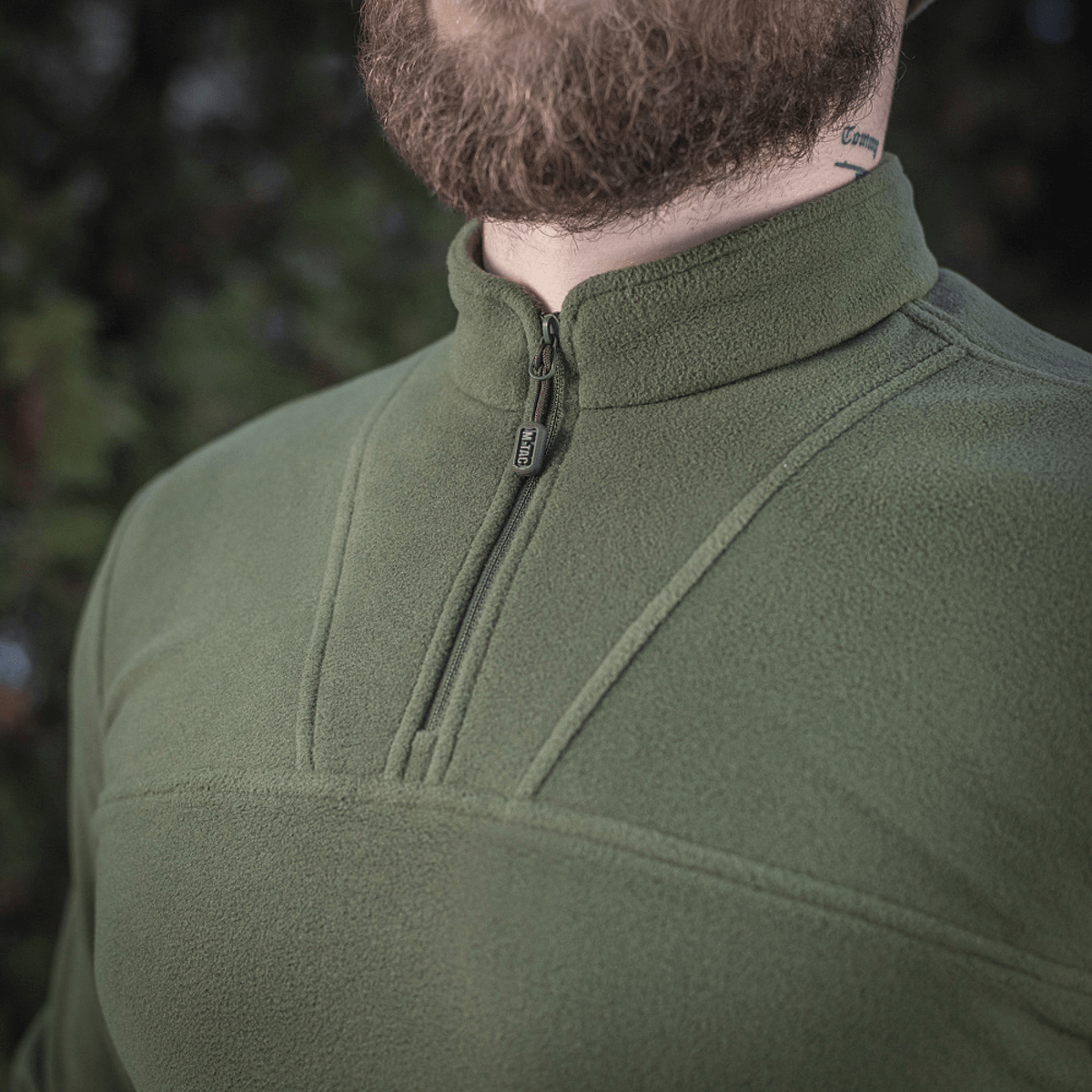Mand iført M-Tac Delta Polartec Fleecejakke i grøn med halv lynlås, ideel til kolde dage med åndbart, isolerende materiale.