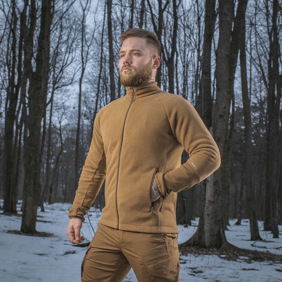 Mand iført M-Tac Polartec Sport Fleecejakke ude i skoven om vinteren