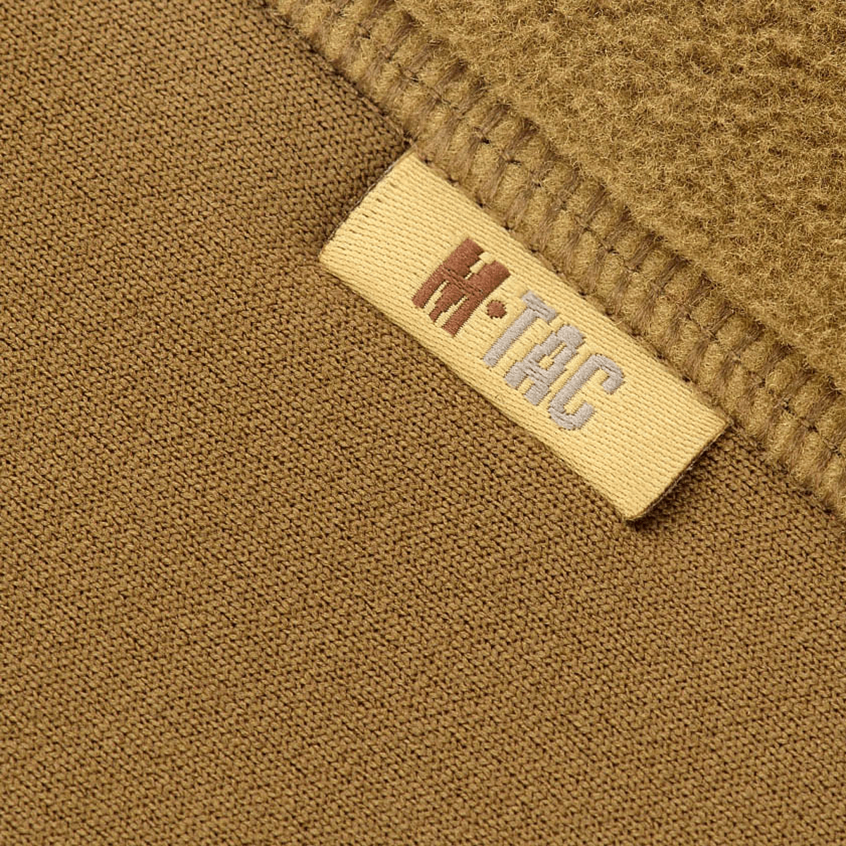 Nærbillede af M-Tac Polartec Sport Fleecejakke materiale og logo, der viser fleece's struktur og holdbarhed.