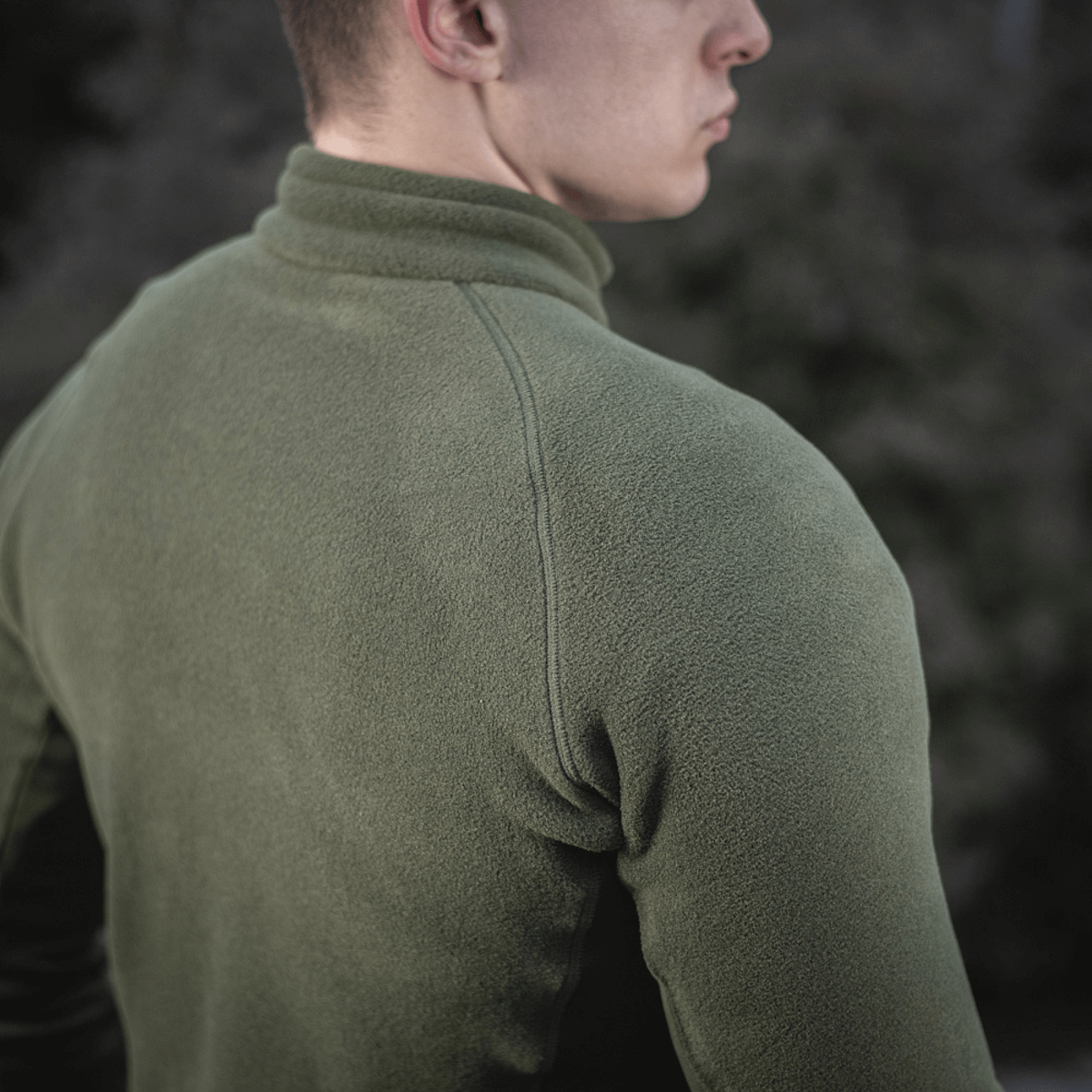 M-Tac Polartec Sport Fleecejakke set bagfra i udendørs omgivelser, fremhæver komfort og stil i grøn fleece materiale.