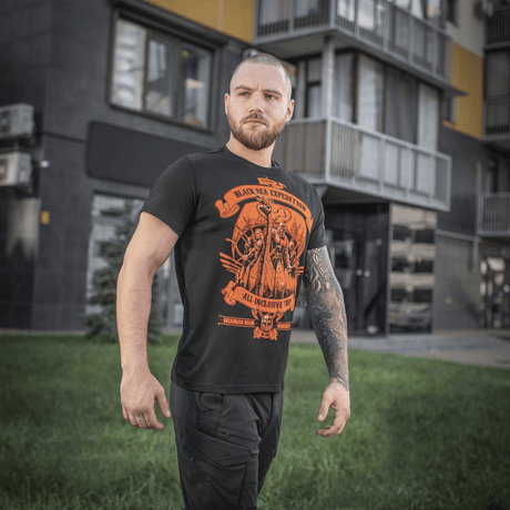 Mand iført sort M-Tac T-shirt Black Sea Expedition i en urban setting, fremviser atletisk snit og unikt print.