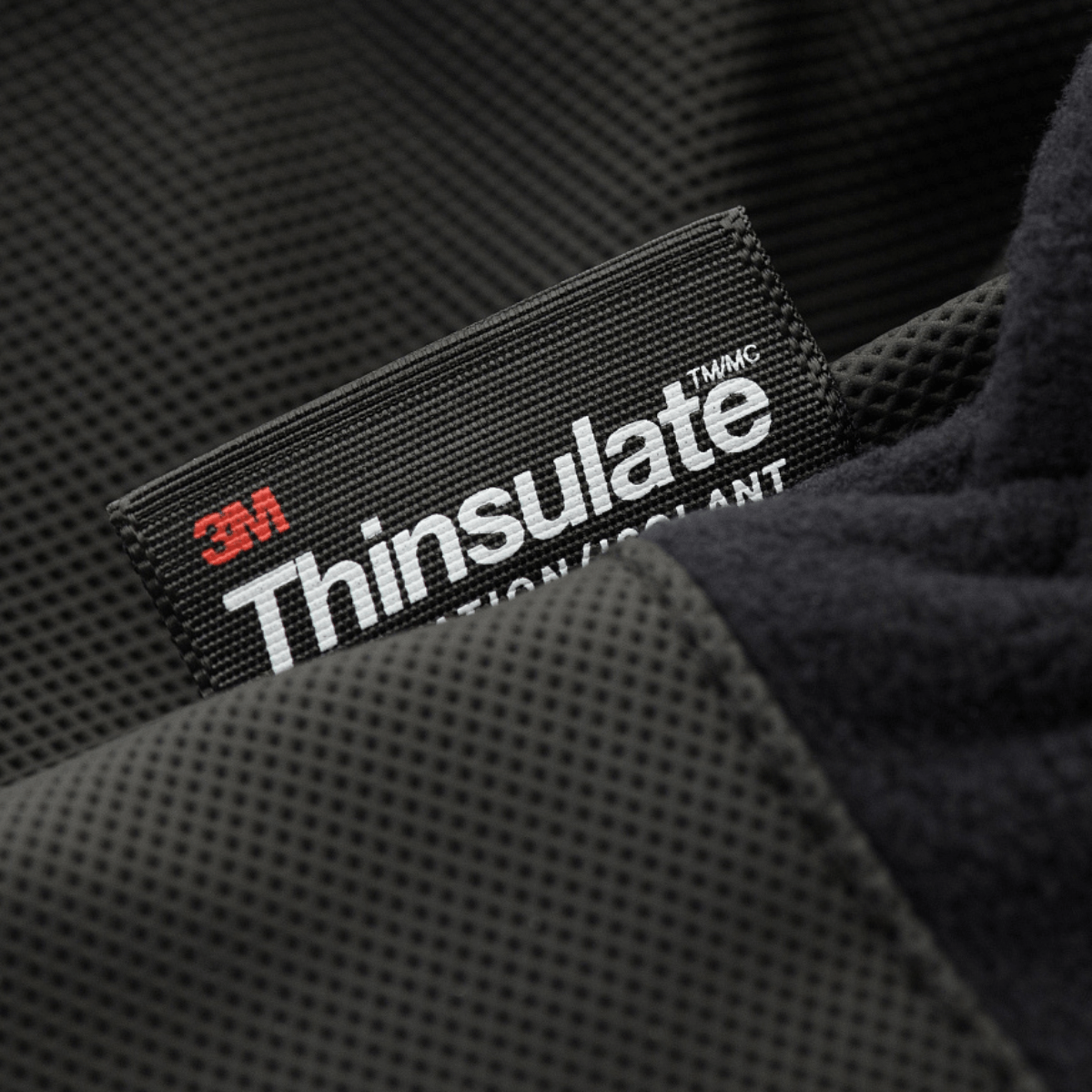 Close-up af sort M-Tac Handsker Fleece Thinsulate label med 3M Thinsulate teknologi for overlegen isolering og kuldebeskyttelse.
