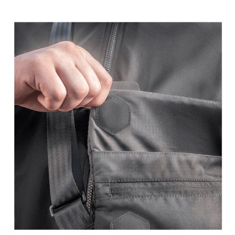 Hånd åbner lomme på M-Tac Konvert Taske Elite fremstillet af holdbart Cordura-materiale med magnetisk ventilåbning.