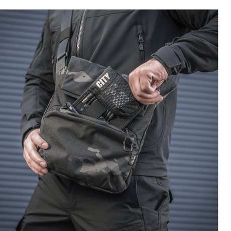M-Tac Konvert Taske Elite i brug, lavet af slidstærkt Cordura materiale, med justerbar skulderrem og hurtig adgangs magnetventil.