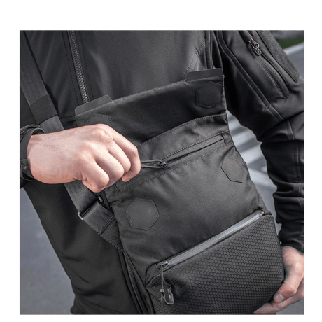 Mand med M-Tac Konvert Taske Elite, lavet af holdbar Cordura, med magnetlukning og justerbar skulderrem.