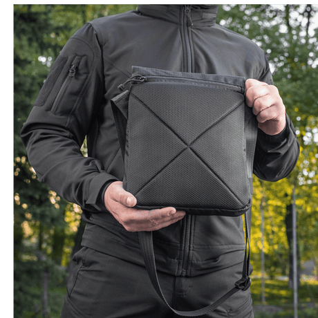 M-Tac Konvert Taske Elite i Cordura 500D og Hex 1000D, med tablet-design og justerbar skulderrem, holdt af person i naturen.