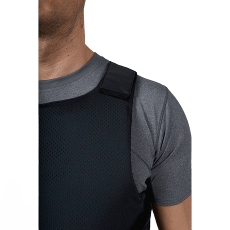 Anorak Concealable I Cover under grå T-shirt, viser lav profil og justerbart skuldersystem.