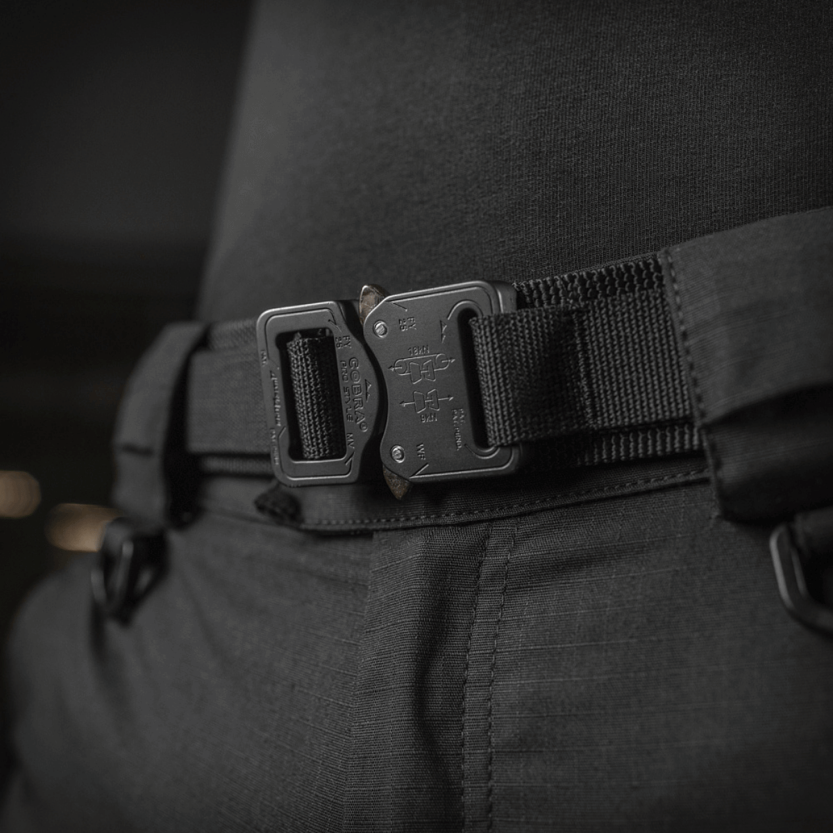 M-Tac Cobra Buckle Taktisk Bælte Gen. II fastgjort om taljen af en person iført sorte bukser, perfekt til militære og aktive aktiviteter.