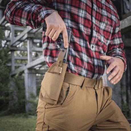 M-Tac Universal Taktisk Hylster Elite Højre med justerbar strop og MOLLE-interface til bælte, vist udendørs med pistol.