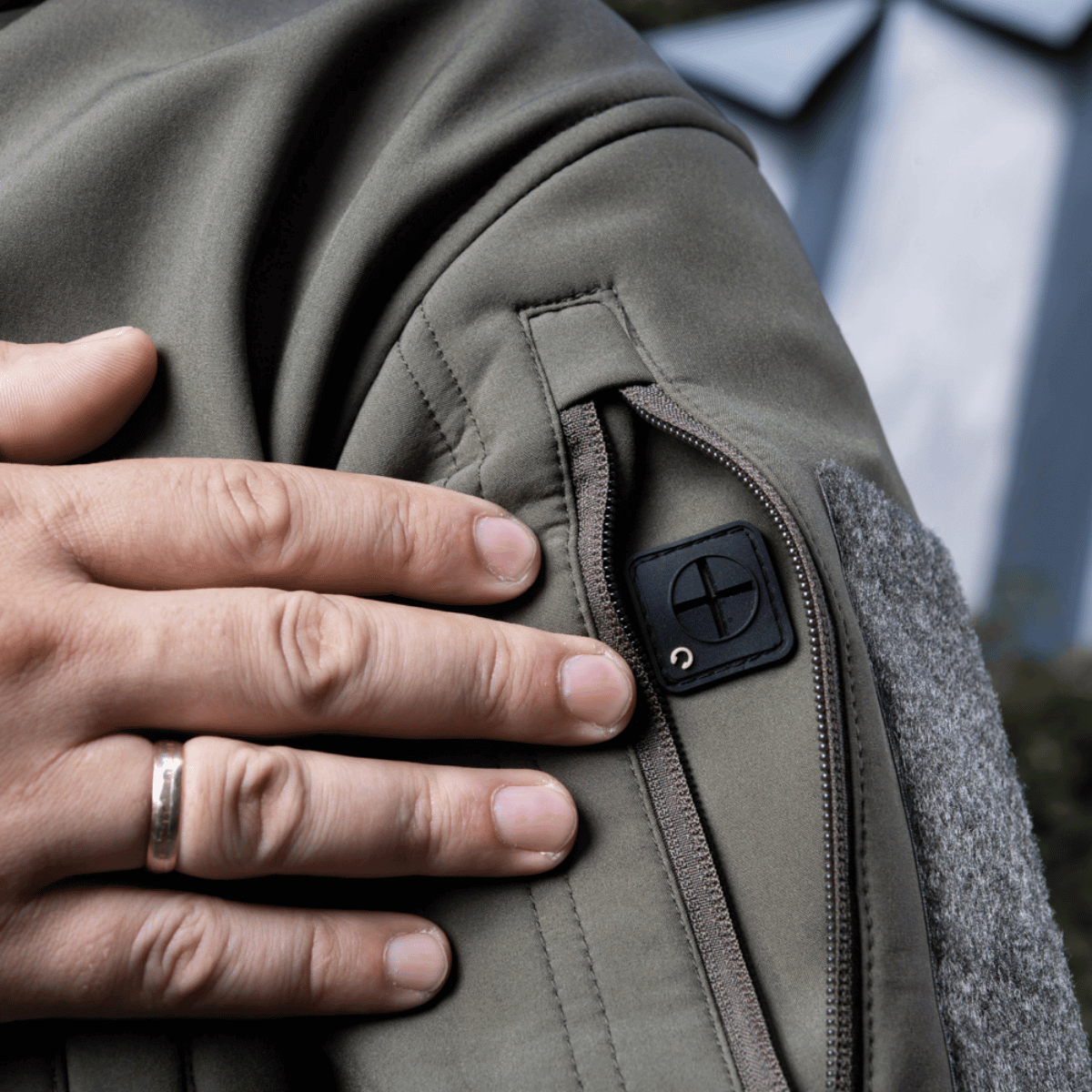 M-Tac Soft Shell Jakke med indvendigt fleece-lag og polyuretan-membran. Hånd placeres på jakkens arm med lynlåsdetalje.