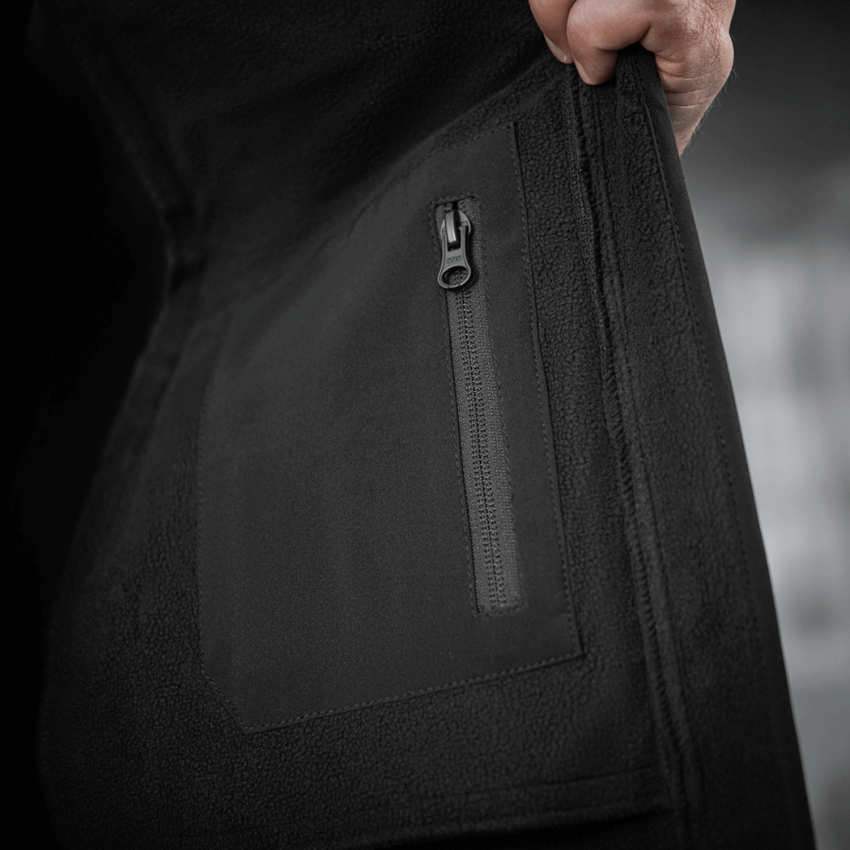 Detalje af lynlås på M-Tac Soft Shell Jakke, lavet med indre polyuretan-membran og fleece-lag, beskytter mod dårligt vejr.