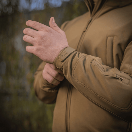 M-Tac Soft Shell Jakke i brug, viser detaljeret syning og justerbare manchetter, ideel til beskyttelse mod dårligt vejr.