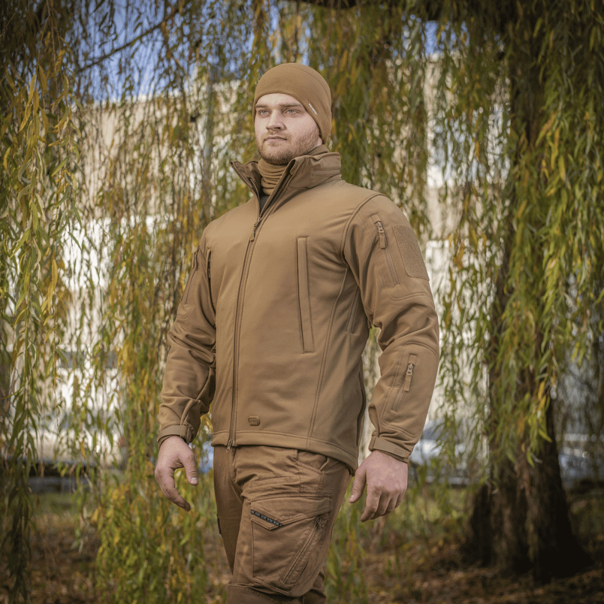 Mand iført M-Tac Soft Shell Jakke designet til beskyttelse mod vejr med polyuretan-membran og fleece indvendigt.