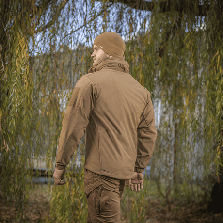M-Tac Soft Shell Jakke i naturen, viser jakkenes vejrbeskyttelse og letvægtsdesign med en indre fleece-membran.