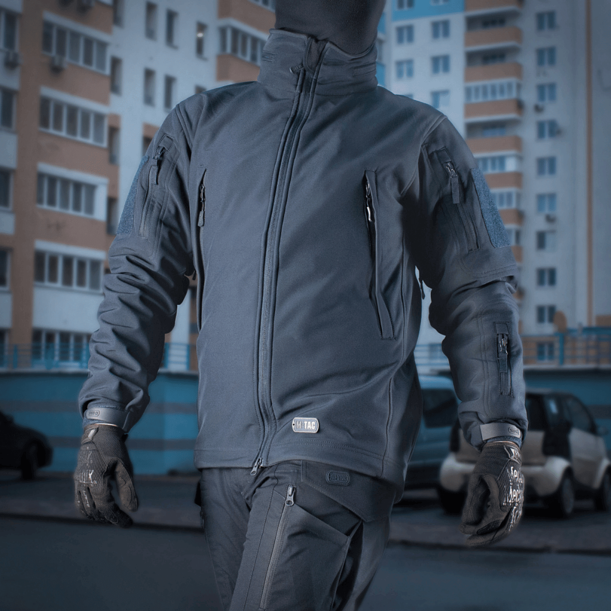 Mand iført M-Tac Soft Shell Jakke med indre polyuretan-membran og fleece-lag til beskyttelse mod vind og vejr