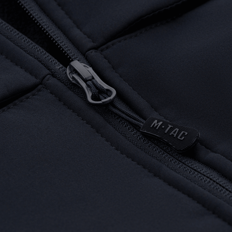 Nærbillede af lynlås og stofdetaljer på en M-Tac Soft Shell Police Jakke, ideel til beskyttelse mod vind og vejr.
