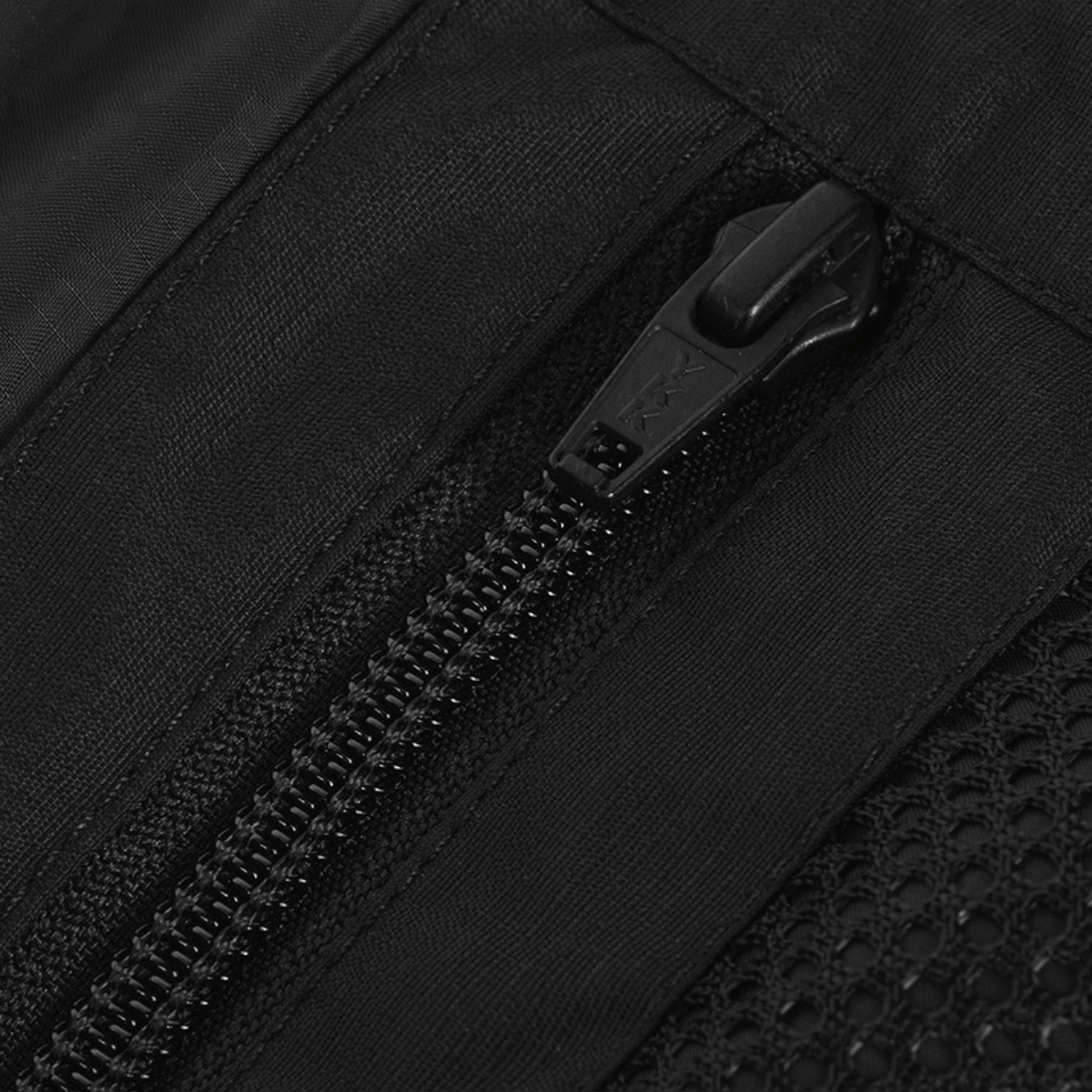 Nærbillede af lynlås på M-Tac Alpha Gen.III Pro Vinterjakke, viser vandafvisende nylon og netfor for holdbarhed og komfort.