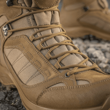 M-Tac Taktiske Sæsonstøvler i ruskind og Cordura, ideelle til terræn og outdoor brug, viser robust snørebinding og detaljer.